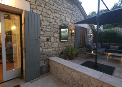 Night time photo, showing large outdoor seating area and doors to inside